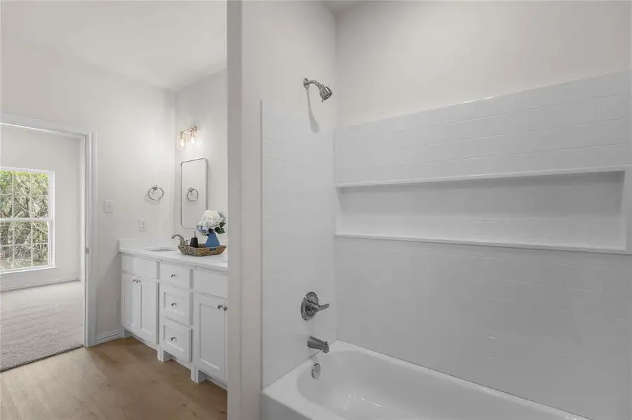 Full bath featuring shower / bathtub combination, light wood-style flooring, and vanity