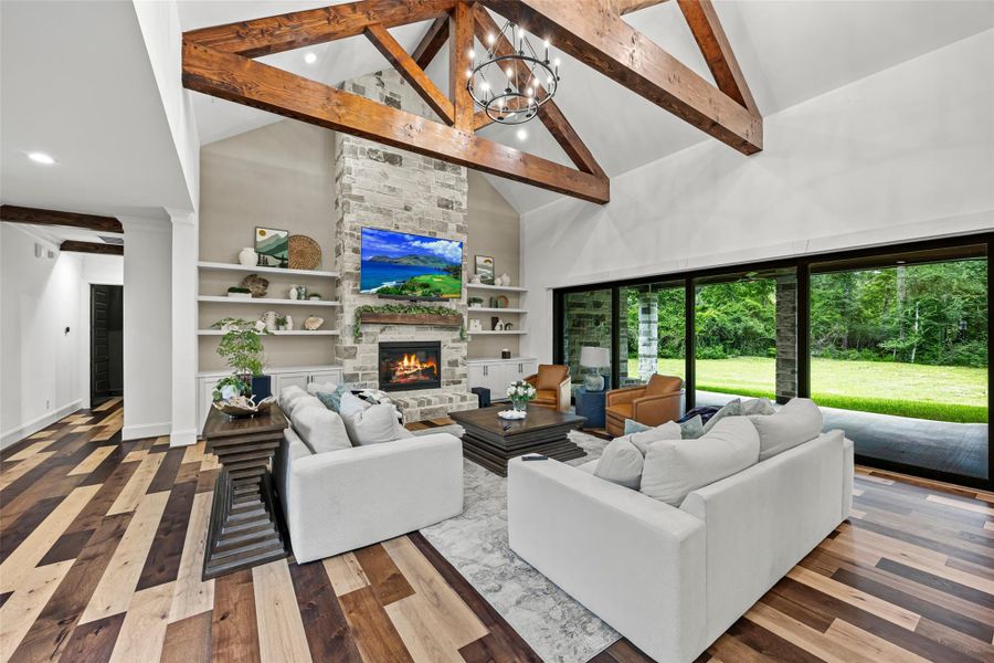 Luxurious open living space featuring a stone fireplace, soaring ceilings, and seamless indoor-outdoor flow. Luxurious open living space featuring a stone fireplace, soaring ceilings, and seamless indoor-outdoor flow.