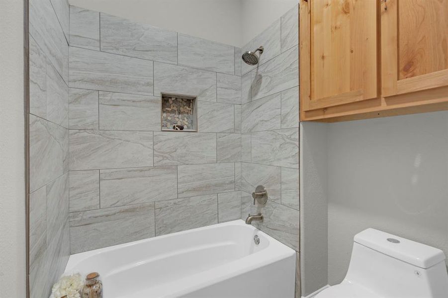 Bathroom with toilet and tiled shower / bath