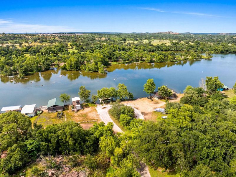 Mature trees frame an aerial perspective of peaceful waterfront acreage along the river.