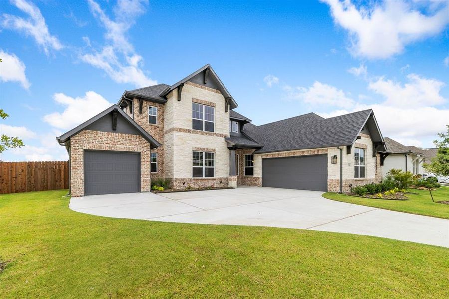 View of front of house with a garage and a front yard