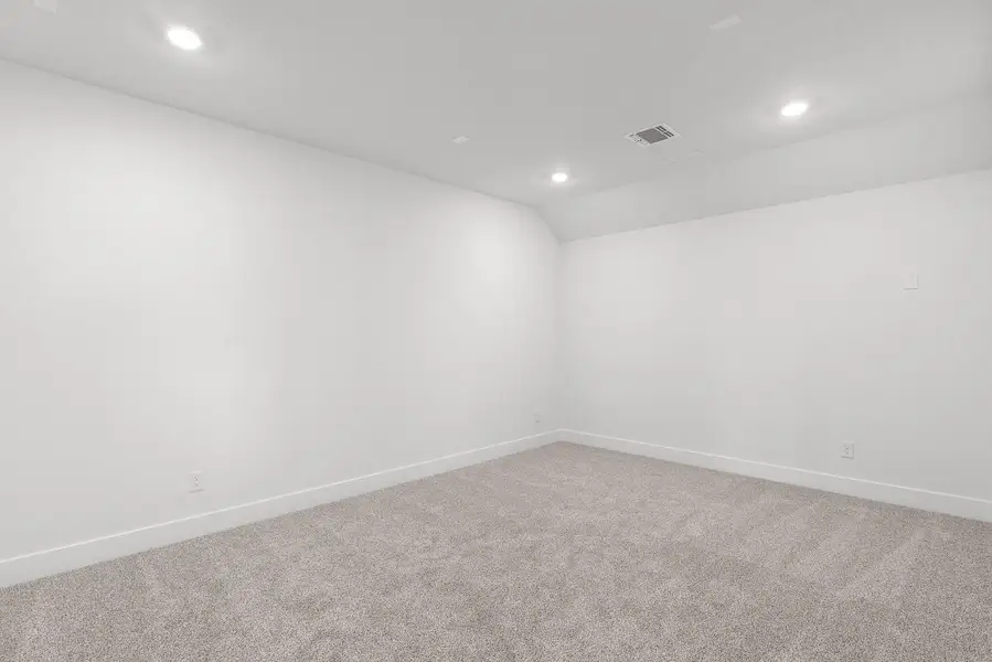 Recessed lighting illuminates this versatile room, offering a neutral palette for any decor.