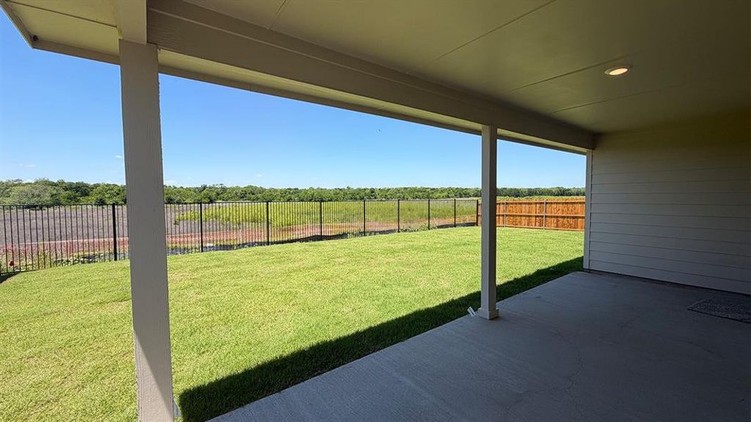 Covered patio with recessed lighting, concrete flooring, and a expansive grassy area