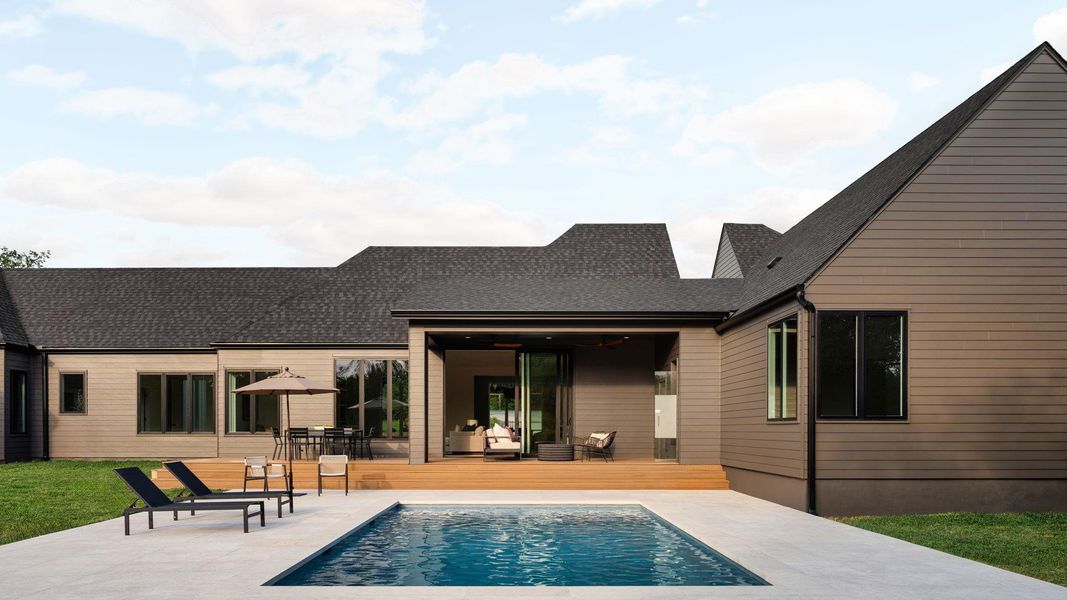 An inviting backyard oasis awaits with a sparkling pool and a spacious wooden deck. An inviting backyard oasis awaits with a sparkling pool and a spacious wooden deck.