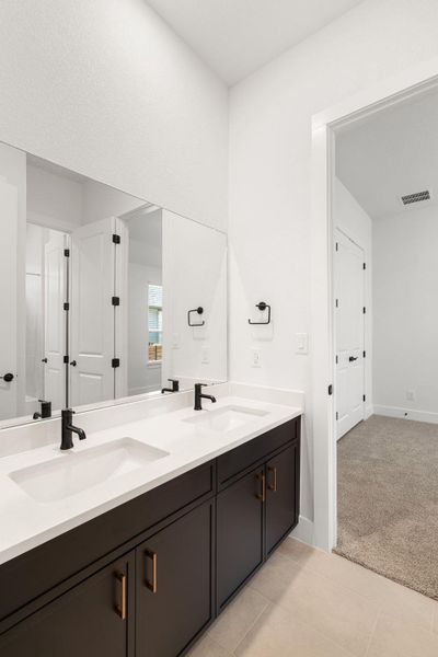 Dual vanity with sleek black fixtures offers ample counter space for daily routines.