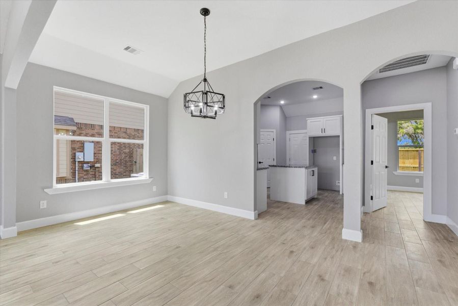 Elegant arched transitions provide a sense of architectural character while maintaining a seamless connection to the kitchen and dining spaces.