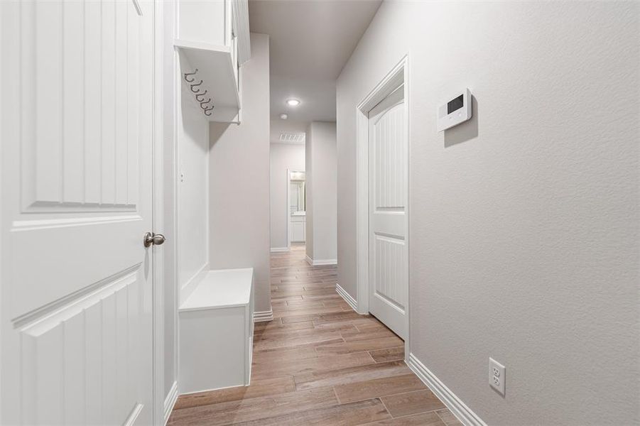 Hallway with baseboards and light wood-type flooring Hallway with baseboards and light wood-type flooring