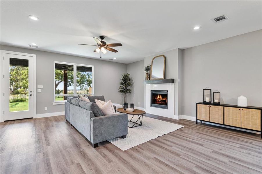 Living room with ceiling fan and light hardwood / wood-style floors