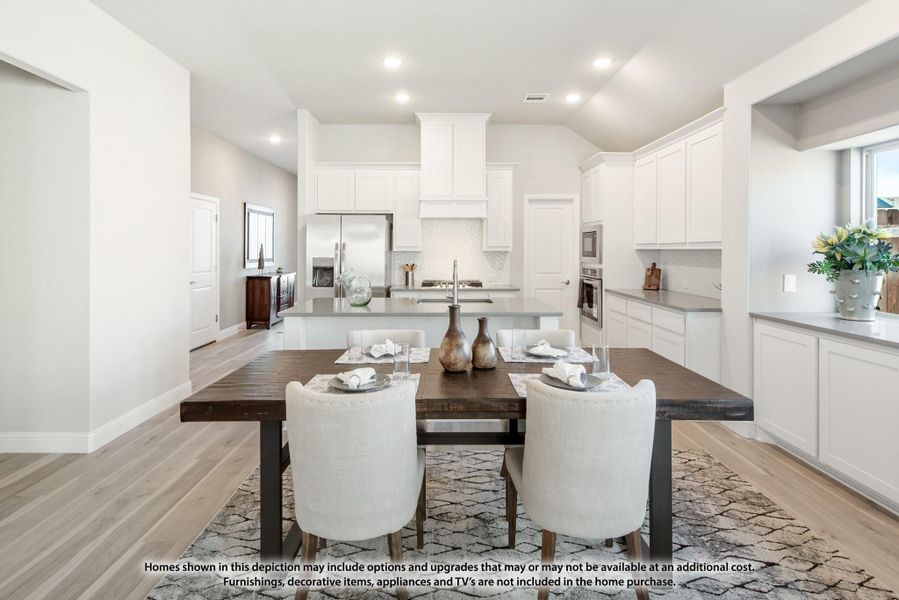 Open dining area with dark wood table and white chairs, adjacent to kitchen with white cabinets and stainless appliances Open dining area with dark wood table and white chairs, adjacent to kitchen with white cabinets and stainless appliances