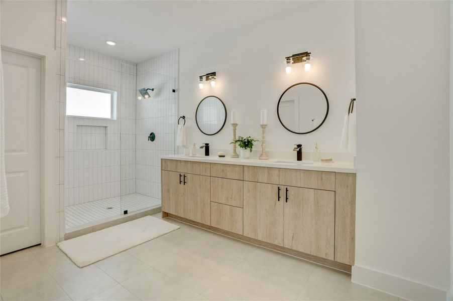 The primary bath has solid wood cabinets, custom lighting, 3cm quartz counters, and custom fixtures.