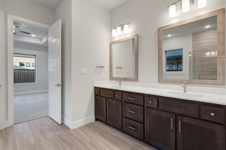 Bathroom with double vanity, recessed lighting, and a shower with door