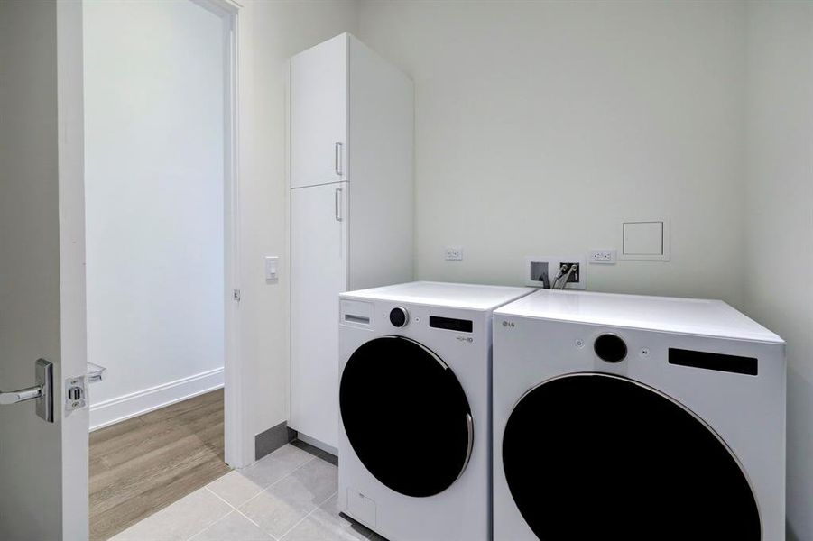 The large laundry room includes storage and a state-of-the-art LG washer and dryer.