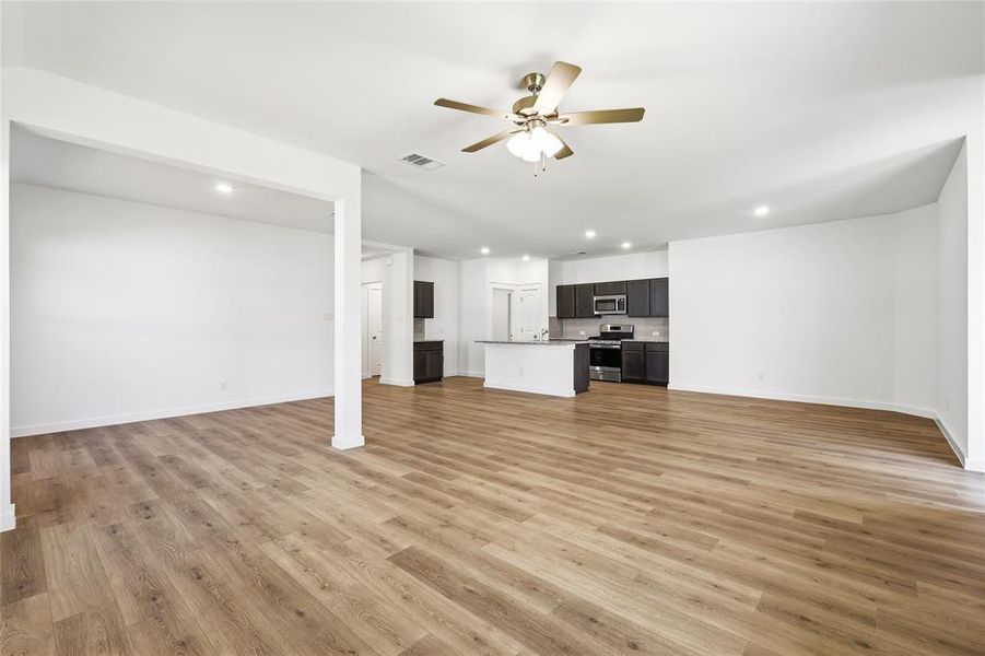 Unfurnished living room with recessed lighting, ceiling fan, and light wood-style floors