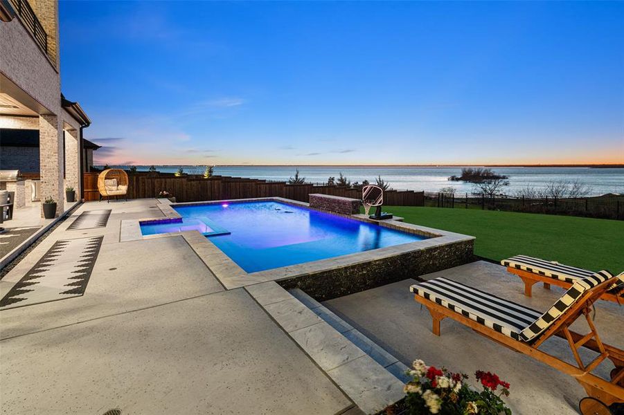 Breathtaking backyard retreat showcasing panoramic lake views and direct lake access, creating a truly one-of-a-kind setting. The oversized yard offers an incredible amount of outdoor space, highlighted by a stunning pool and expansive patio designed for relaxing or entertaining while taking in the spectacular waterfront scenery.
