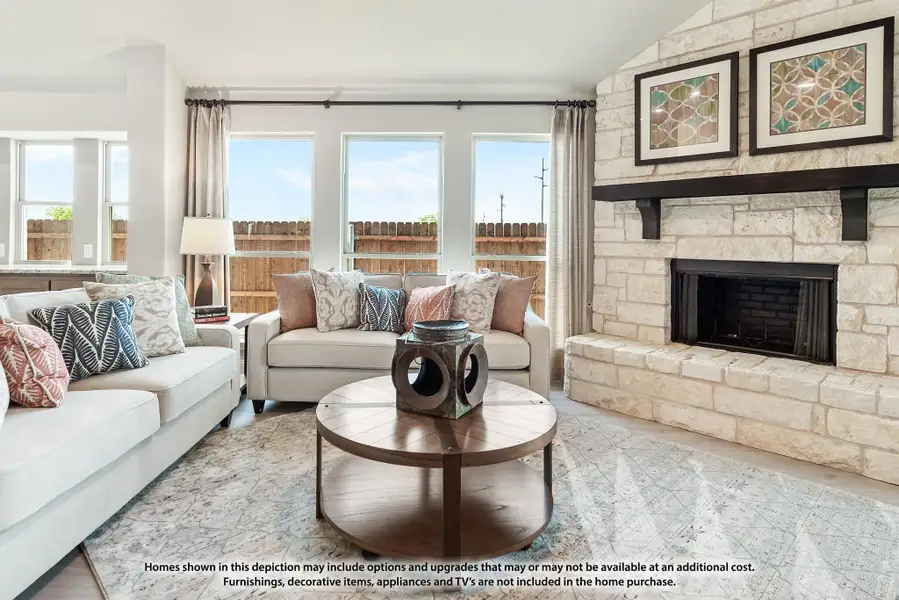 Living room with stone fireplace, two sofas, round wood coffee table, and large windows with natural light Living room with stone fireplace, two sofas, round wood coffee table, and large windows with natural light