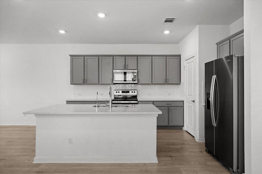Culinary creations come to life in this kitchen, featuring an expansive island and sophisticated cabinetry.