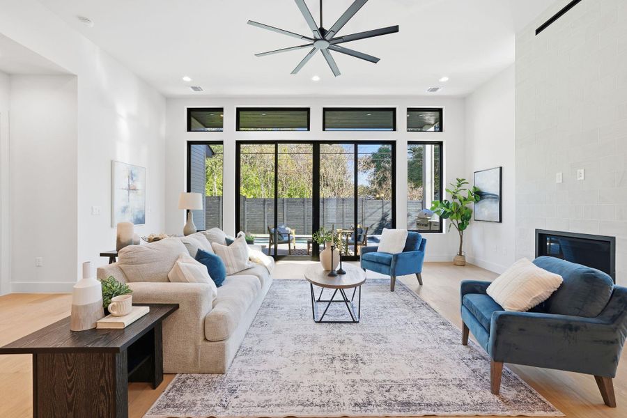 Living area featuring a tile fireplace, recessed lighting, light wood-style floors, and a ceiling fan