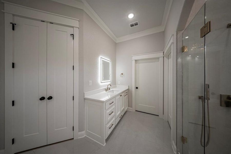 Bathroom with ornamental molding, a shower stall, and vanity Bathroom with ornamental molding, a shower stall, and vanity