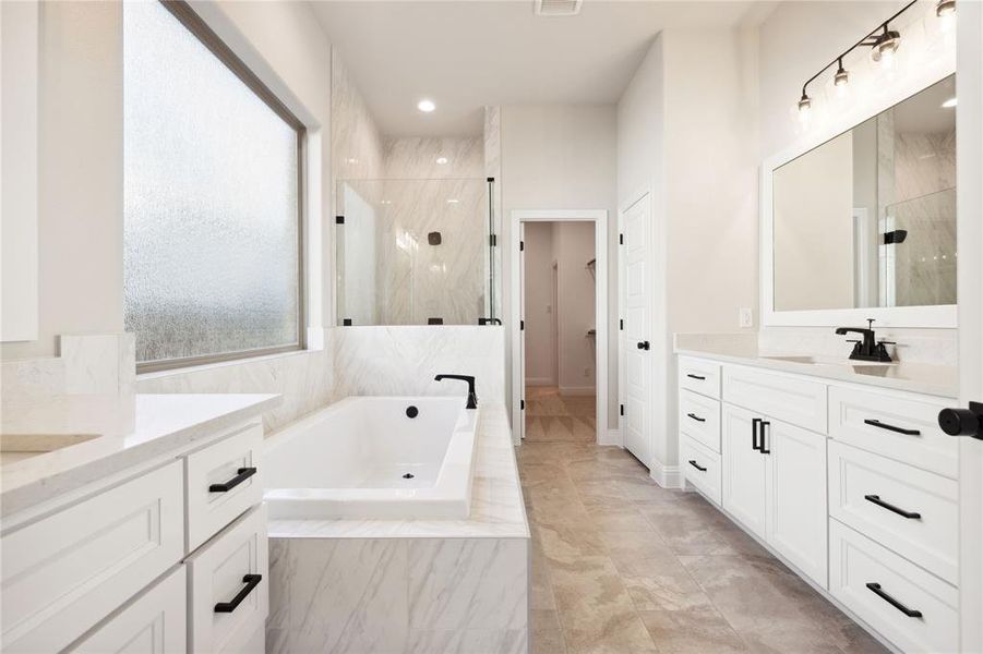 Bathroom featuring vanity and shower with separate bathtub