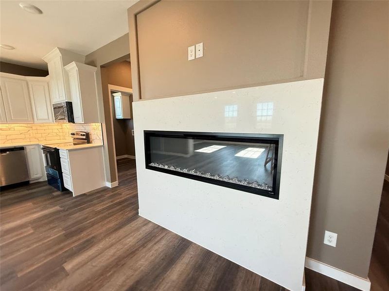 Kitchen with tasteful backsplash, stainless steel appliances, dark hardwood / wood-style floors, and white cabinets