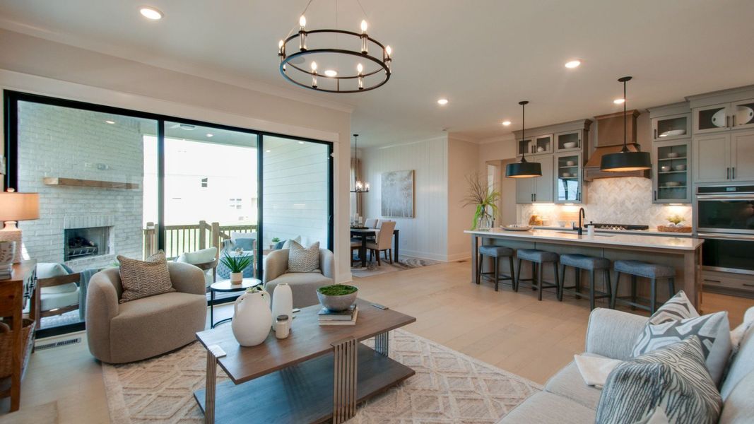 Gathering room with connecting kitchen/dining area and large glass sliding doors out to the covered outdoor patio space Gathering room with connecting kitchen/dining area and large glass sliding doors out to the covered outdoor patio space