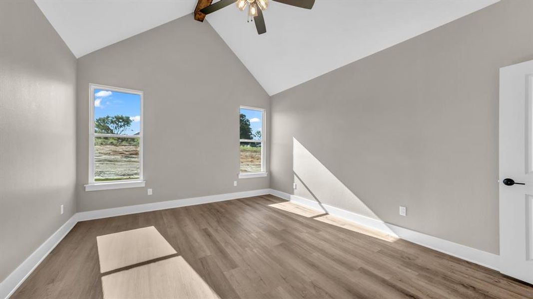 Primary Bedroom featuring light wood-type flooring, beam ceiling, ceiling fan, and high vaulted ceiling