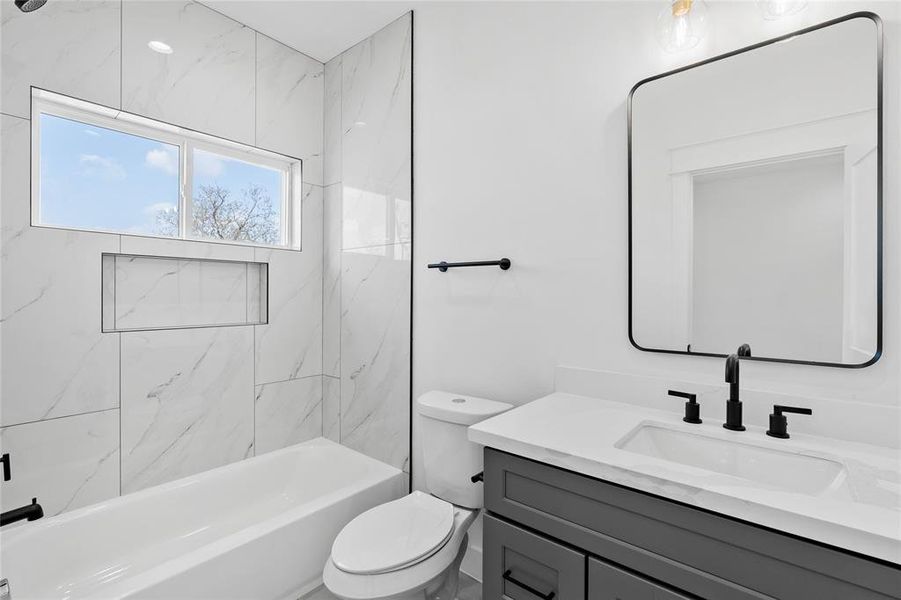 Continuing the home's cohesive design, the secondary bathroom exudes a seamless aesthetic, ensuring a harmonious flow and unified style throughout.