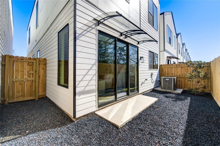Charming fenced backyard with a stylish covered awning, perfect for outdoor relaxation.