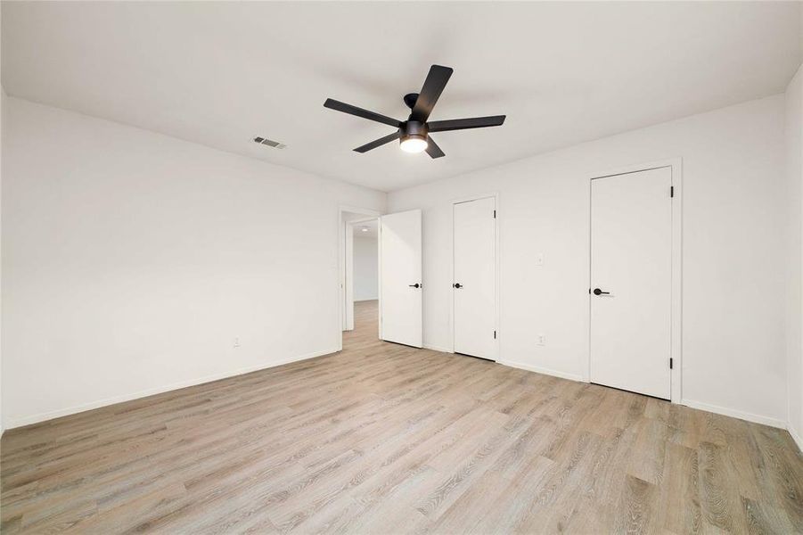 Unfurnished bedroom with light wood-style floors, visible vents, ceiling fan, and baseboards Unfurnished bedroom with light wood-style floors, visible vents, ceiling fan, and baseboards