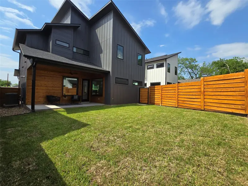 Rear view of house with a ceiling fan, a fenced backyard, a yard, board and batten siding, and a patio Rear view of house with a ceiling fan, a fenced backyard, a yard, board and batten siding, and a patio