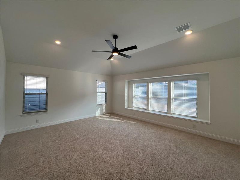 Spacious master bedroom with carpet flooring, ceiling fan, lofted ceiling, recessed lighting, and over-sized walk-in closet Spacious master bedroom with carpet flooring, ceiling fan, lofted ceiling, recessed lighting, and over-sized walk-in closet