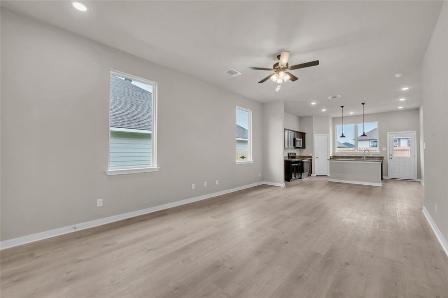 Unfurnished living room with recessed lighting, ceiling fan, and light wood-style floors