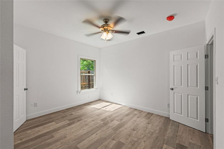 Empty room featuring hardwood / wood-style flooring and ceiling fan