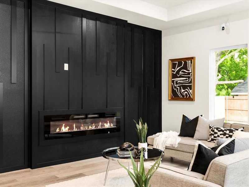 Living room featuring a glass covered fireplace and wood finished floors