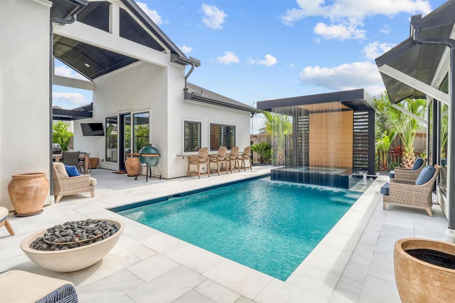 Soak in the view of this spectacular tropical oasis! Pool and Spa feature a one-of-a-kind custom rushing waterfall. An outdoor bar connects to a casita with a full kitchen, bedroom, bathroom, and living room. A breezeway provides covered dining and leads to a full outdoor kitchen and green space. The entire deck is done in the finest sparkling white travertine tile!