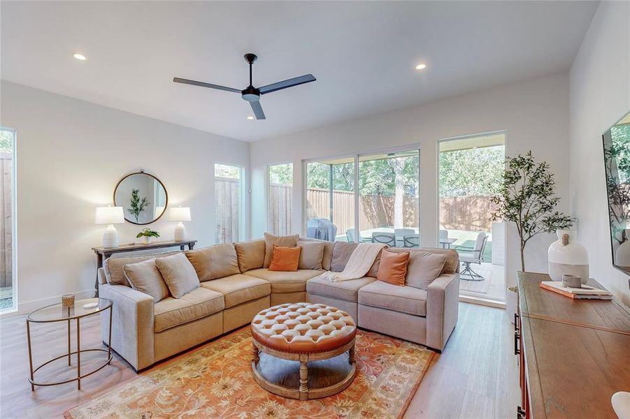 Living room with ceiling fan and light wood-type flooring