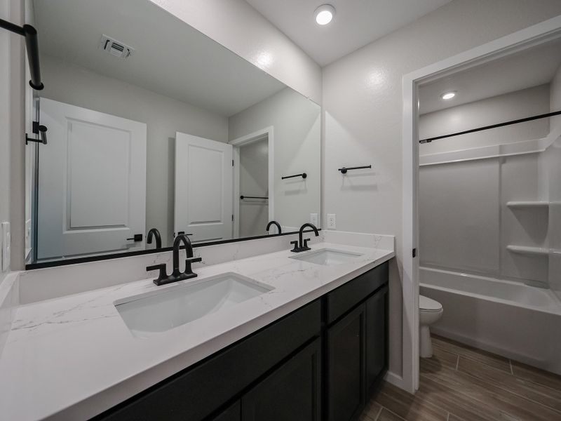 A bathroom with a tub sink and toilet.