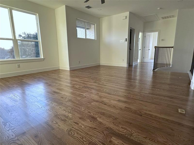 Empty room featuring dark wood-type flooring and ceiling fan