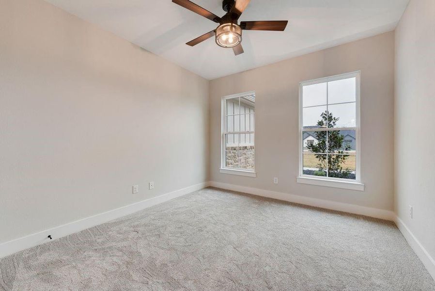 Carpeted spare room with ceiling fan