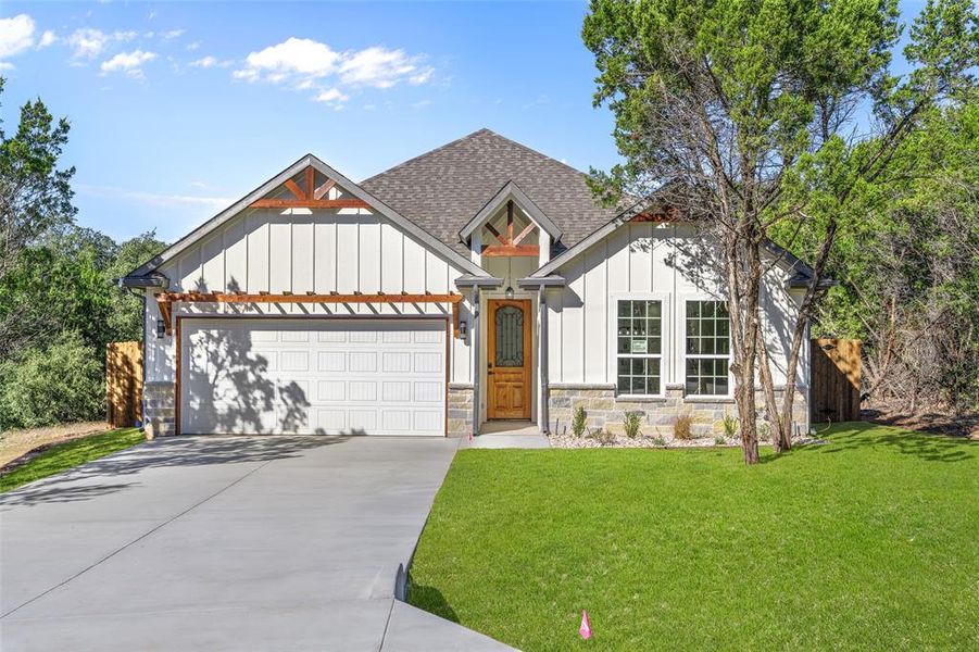 View of front of home with a front yard and a garage