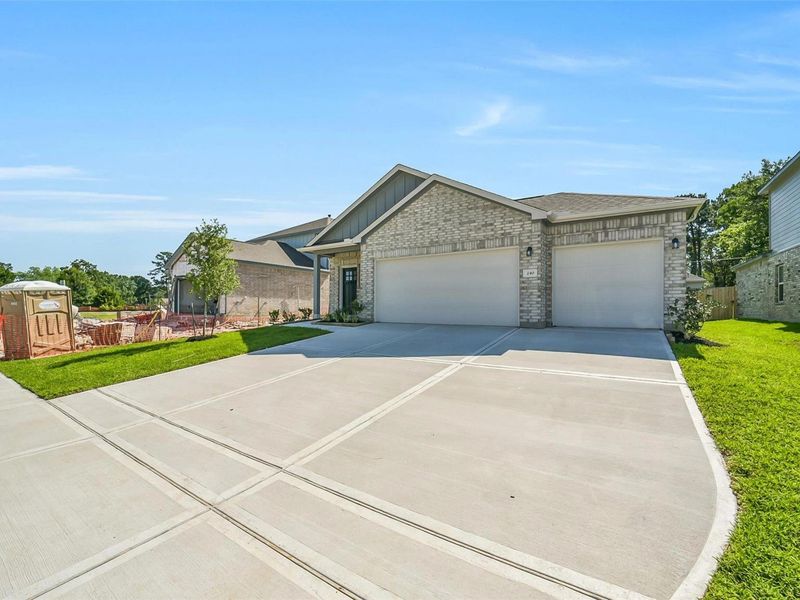 Front exterior of a new home in Windmill Estates, Magnolia, TX, highlighting curb appeal (Image 2). Front exterior of a new home in Windmill Estates, Magnolia, TX, highlighting curb appeal (Image 2).