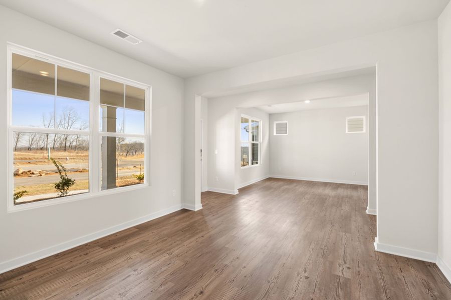 A room with a wood floor and a window with a view of the outside. A room with a wood floor and a window with a view of the outside.