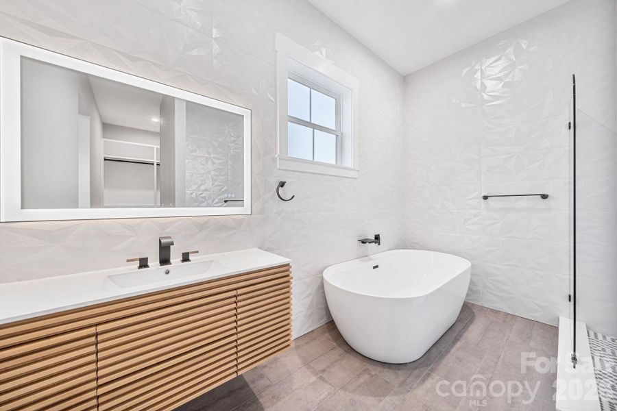 Full bathroom, tile walls, soaking tub, walk-in shower, floating vanity
