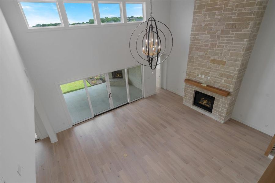 Unfurnished living room with a healthy amount of sunlight, light wood-type flooring, and a chandelier