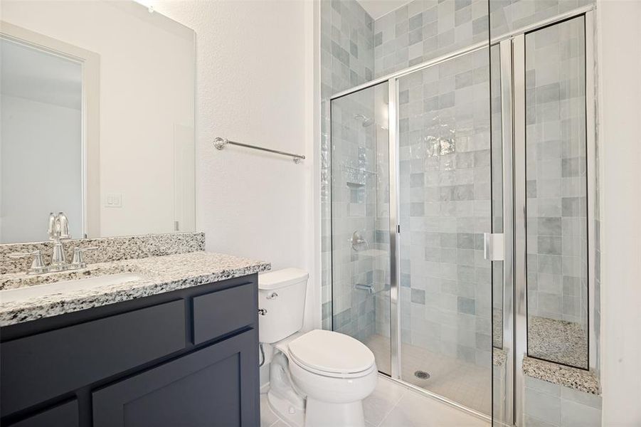 Glass-enclosed shower with gray and white tiled surround Glass-enclosed shower with gray and white tiled surround