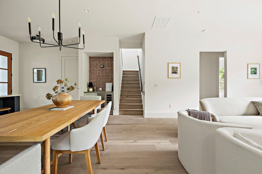 Dining area with stairway, a chandelier, light wood-type flooring, and baseboards
