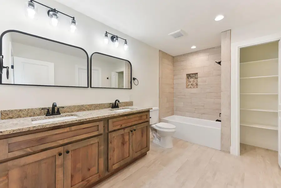 Jack 'n Jill Bathroom featuring toilet, wood plank tile floors, a sink, and double vanity