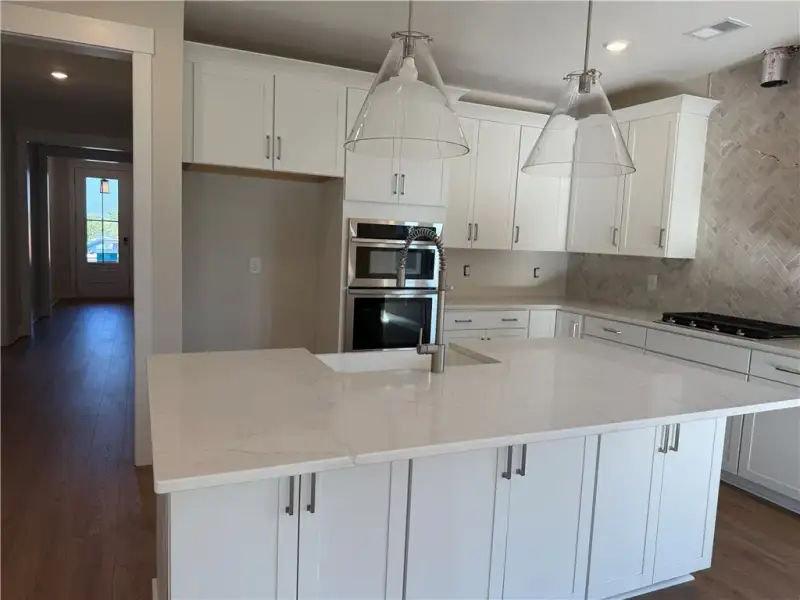Gleaming stone countertops and shaker cabinetry an