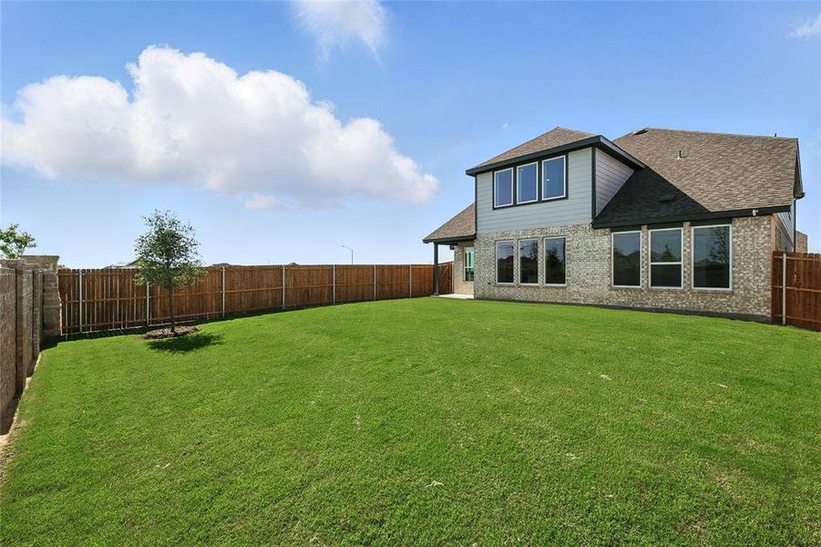 Back of house with roof with shingles, a fenced backyard, and brick siding Back of house with roof with shingles, a fenced backyard, and brick siding