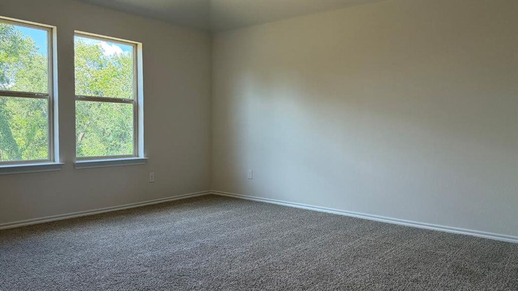 Room featuring two large windows, neutral wall paint, and gray carpet flooring